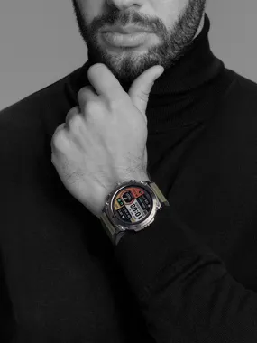 Zbliżenie na brodatego mężczyznę w czarnym golfie, z dłonią na brodzie i smartwatchem na nadgarstku.